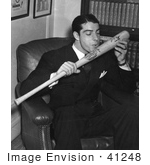 #41248 Stock Photo of The New York Yankees Baseball Player, Joe Dimaggio, Sitting In A Chair And Kissing His Signature Baseball Bat, 1941 by JVPD