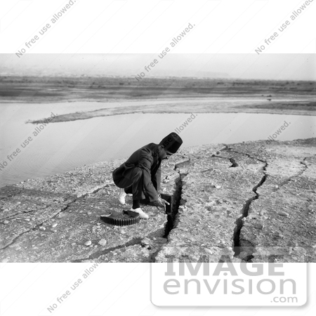 #12877 Picture of an Arabian Man Kneeling Besides Earthquake Fissures, Jordan by JVPD