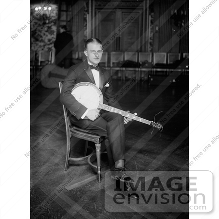 #20819 Stock Photography of a Man Sitting in a Chair and Resting a Banjo on His Lap by JVPD