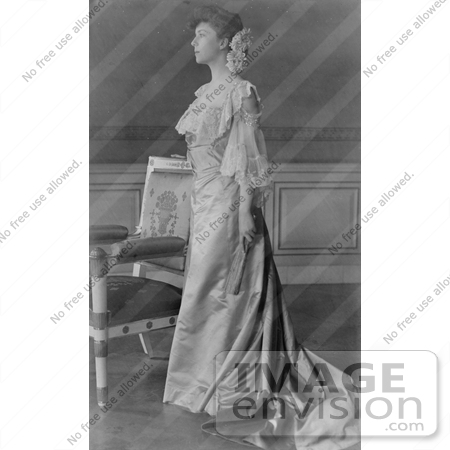 #21442 Stock Photography of Alice Roosevelt Longworth in a Gown, Standing by a Chair and Holding a Folded Hand Fan by JVPD