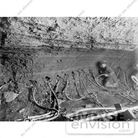 #27013 Stock Photography of The Interior Of A Mine With A Miner Inserting Water Tubes In The Side Of The Shaft in Nome, Alaska, 1909 by JVPD