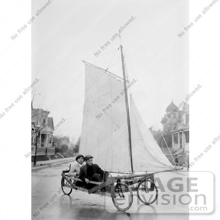 #27642 Stock Photo of Two Men Pedaling Down The Street In Brooklyn, New York On A Sail Wagon, Also Known As A Sand Yacht Or Land Yacht by JVPD