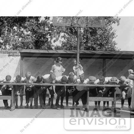 #27892 Historical Stock Photo of An Excited Boy Clinging To A Basketball Hoop Pole While He And A Teacher Watch Boys Shoving Their Faces Into Pies While Competing During A Pie Eating Contest In 1923 by JVPD