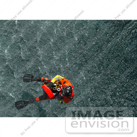 #30641 Stock Photo of a Coast Guard Rescue Diver Being Hoisted Back Up From the Water After Rescuing a Practice Dummy by JVPD