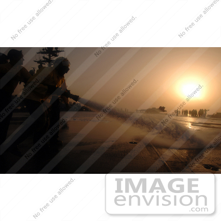 #30646 Stock Photo of United States Navy Sailors Spraying Down the Flight Deck of the USS Harry S. Truman (CVN 75) Aircraft Carrier With a Fire Hose at Sunset by JVPD