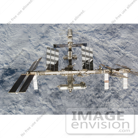 #30724 Stock Photo Of The International Space Station As Seen From Space Shuttle Discovery As The Two Spacecraft Begin Their Relative Separation Over A Cloud Covered Earth On June 11th 2008 by JVPD