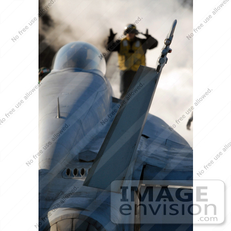 #35239 Stock Photo of U.S. Navy Aviation Boatswain’s Mate 3rd Class Kevin Esquivel Directing An F/a-18e Super Hornet Aircraft Into Position On An Aircraft Carrier Catapult by JVPD