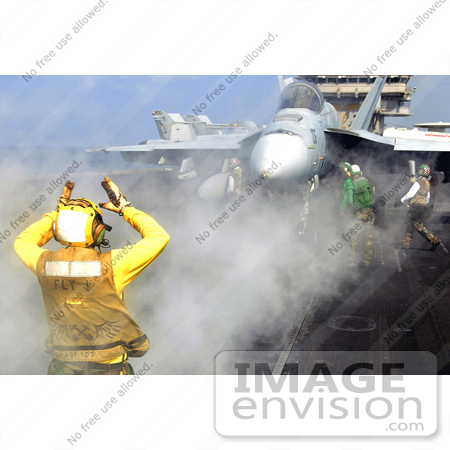 #36175 Stock Photo of a U.S. Navy Aviation Boatswain’s Mate Directing An F/A-18 Super Hornet Aircraft by JVPD