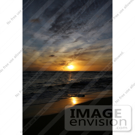#36513 Stock Photo of a Deep Orange Sunset With Blue Skies Above, Reflecting Off Of The Wet Sand And Waves On The Pacific Ocean, Poipu, Kauai, Hawaii by Jamie Voetsch