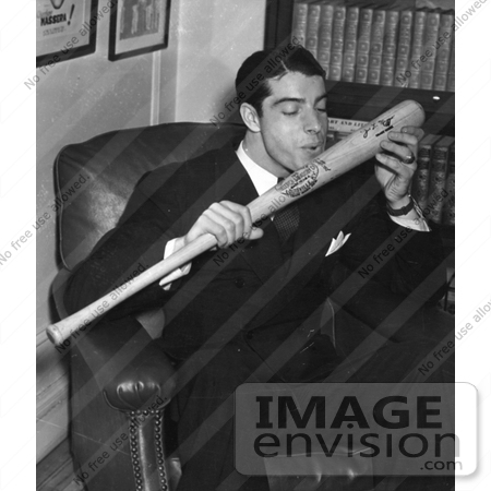 #41248 Stock Photo of The New York Yankees Baseball Player, Joe Dimaggio, Sitting In A Chair And Kissing His Signature Baseball Bat, 1941 by JVPD