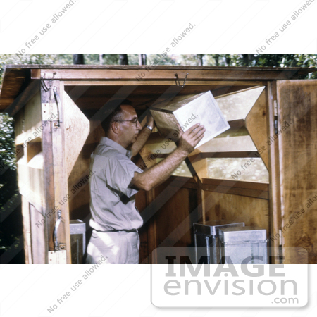 #5179 Stock Photography of a Cdc Field Researcher Moving a Mosquito Cage from a Horse Stable Mosquito Trap by JVPD