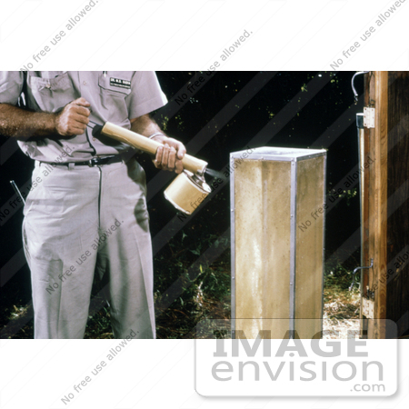 #5180 Stock Photography of a Field Researcher Using a Hand-Held Sprayer to Knock Down Mosquitoes from the Screen of a Horse Stable Mosquito Trap by JVPD