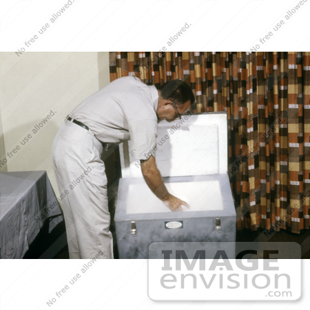 #5201 Picture of a Field Researcher Placing Pint Cartons Containing Mosquito-Filled Tubes Into a Freezer to Preserve the Specimens by JVPD