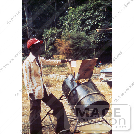 #6443 Picture of a Person Standing Beside a Rice Processing Machine at a 1976 Sierra Leone Lassa Fever Field Study by KAPD
