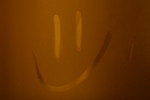 Smiley Face Drawn on a Condensated Bathroom Mirror