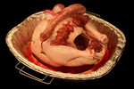 Uncooked Heart, Liver, Gizzard, and Neck on a Raw Turkey in a Roasting Pan