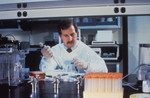Lab Technician Pipetting Specimens While he Conducts Laboratory Research