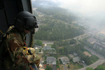 Soldier Overlooking a City From a Helicopter