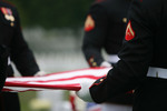 Men Holding a Flag After a Funeral Ceremony