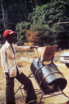 Person Standing Beside a Rice Processing Machine at a 1976 Sierra Leone Lassa Fever Field Study
