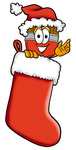 Clip Art Graphic of a Red Paintbrush With Yellow Paint Cartoon Character Wearing a Santa Hat Inside a Red Christmas Stocking