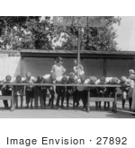 #27892 Historical Stock Photo Of An Excited Boy Clinging To A Basketball Hoop Pole While He And A Teacher Watch Boys Shoving Their Faces Into Pies While Competing During A Pie Eating Contest In 1923