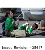 #35647 Stock Photo Of Male And Female US Navy Sailors Removing A Data Bus From The Nose Of A Hh-60h Seahawk