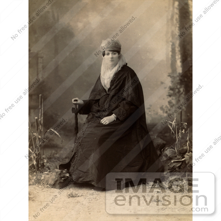 #19098 Photo of a Turkish Woman Wearing a Niqab Veil on Her Face, Sitting in a Chair, Holding a Parasol by JVPD