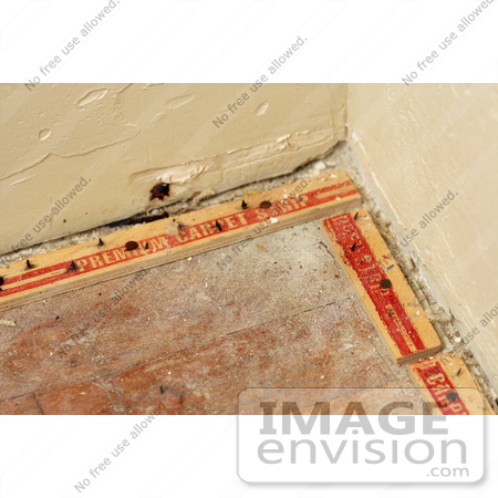 #21925 Stock Photography of Nails in Two Tack Strips Meeting in a Corner on a Dusty Wood Floor Following the Removal of Carpet and Padding by Jamie Voetsch