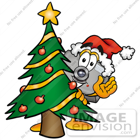#23134 Clip Art Graphic of a Flash Camera Cartoon Character Waving and Standing by a Decorated Christmas Tree by toons4biz