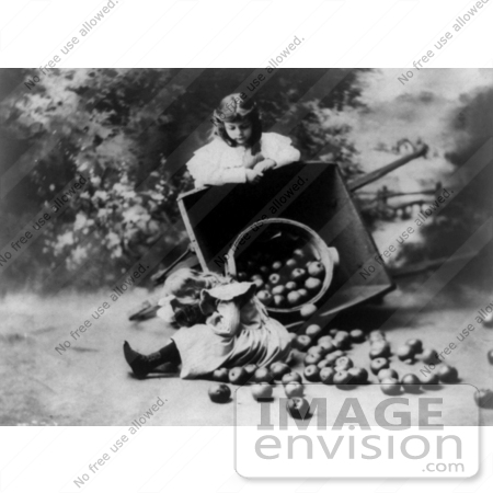 #26691 Stock Photography of a Calm Girl Resting on a Tipped Wheelbarrow, Watching Her Young Sister Cry After Tipping Over a Bushel of Apples by JVPD