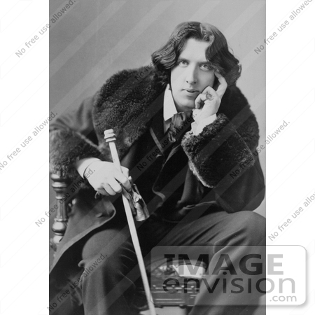 #35630 Stock Photo of Oscar Wilde In A Coat, Sitting In A Chair With His Hand Touching His Face, Holding A Walking Stick by JVPD