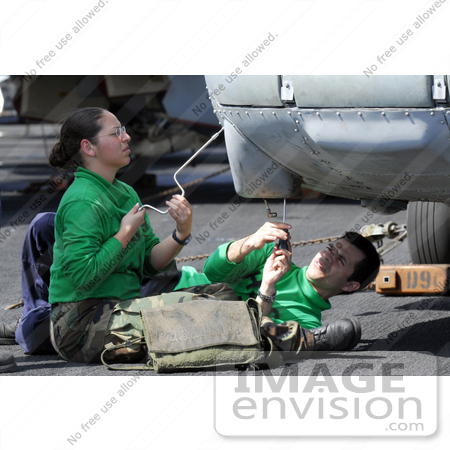 #35647 Stock Photo Of Male And Female U.S. Navy Sailors Removing A Data Bus From The Nose Of A HH-60H Seahawk by JVPD