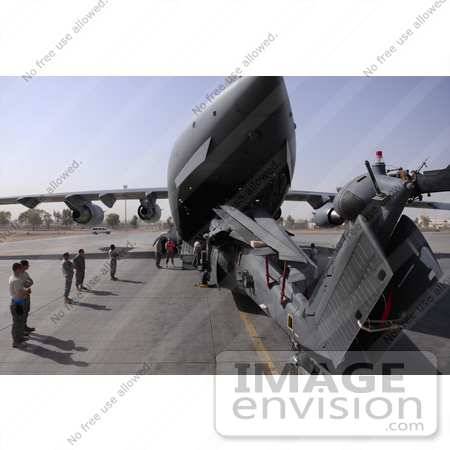 #35648 Stock Photo Of U.S. Airmen Watching A Hh-60 Pave Hawk Helicopter Loading Into A C-17 Globemaster Iii Aircraft On Joint Base Balad, Iraq by JVPD