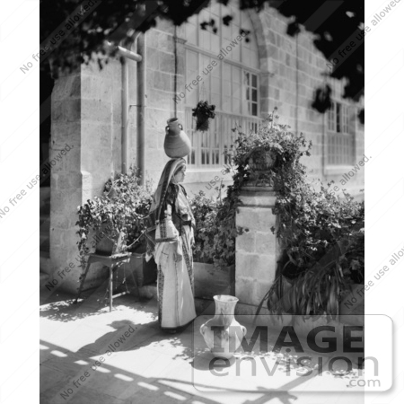 #43469 RF Stock Photo Of A Black And White Ramallah Woman Balancing A Jug On Her Head On A Patio by JVPD