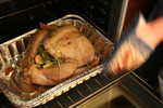 Person Putting a Turkey in an Oven