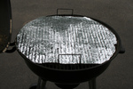 Foil With Holes Covering a Rusty BBQ Grill