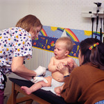 Physician and an Assistant Administering a Hepatitis B Vaccination to a 9 Month Old Baby