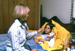 Mother Caring for Her Child who is in Bed Sick with a Cold - 1976