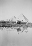 Man on Camel Near Pool of Water, Pyramids in the Background