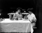 Two Women Using a Toaster at a Table