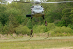 Soldiers Hanging on Ropes Under a Helicopter