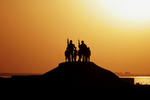 Soldiers and Children Silhouetted Against a Sunset