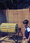 Boy Standing Beside a Rice Threshing Machine at a 1976 Sierra Leone Lassa Fever Field Study