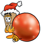 Clip Art Graphic of a Cardboard Shipping Box Cartoon Character Wearing a Santa Hat, Standing With a Christmas Bauble
